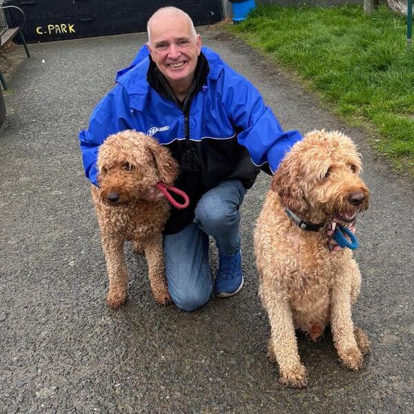 Steve Gunn kneeling beside two dogs outdoors